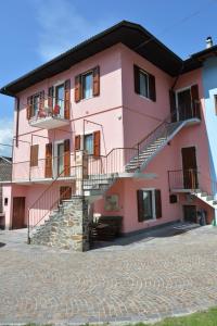 ein rosafarbenes Gebäude mit seitlicher Treppe in der Unterkunft Appartamenti Nadalini in Levico Terme