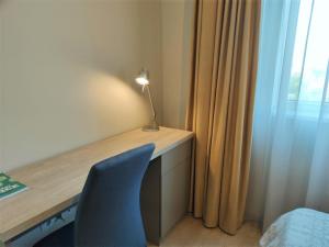 a desk with a blue chair next to a window at SWEET HOME - central cozy apartment in Cluj-Napoca