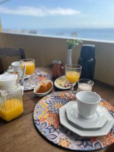 una mesa con platos de comida y vasos de zumo de naranja en Pousada Beija Flor, en Salvador