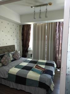 een slaapkamer met een bed met een zwart-witte deken bij Azure Urban Resort Residences Staycation in Manilla