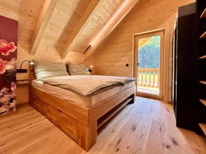 1 dormitorio con 1 cama en una cabaña de madera en Das Grünhaus - Dein Chalet in Grünau im Almtal, en Grünau im Almtal