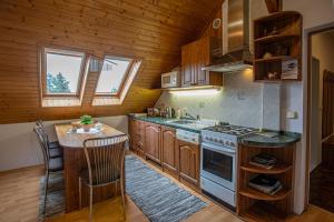 a kitchen with wooden cabinets and a stove and a table at Penzion Eva Krnov in Krnov