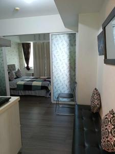 een kamer met een slaapkamer met een bed en een bank bij Azure Urban Resort Residences Staycation in Manilla