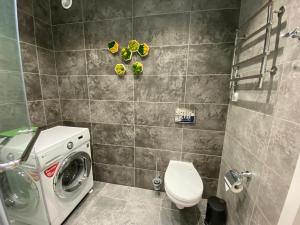 La salle de bains est pourvue de toilettes et d'un lave-linge. dans l'établissement Apartament LETO, à Astana
