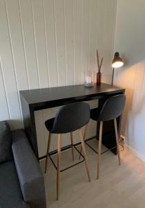 a desk with two chairs and a lamp in a room at Appartment close to the city, ocean and mountains -Tromsø in Tromsø +15 photos