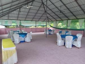 a tent with blue and white tables and white chairs at Padmatheertham Inn in Varkala