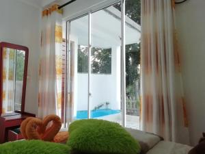 a bedroom with a large window with a view of a pool at ELLA Delightful Surround in Ella