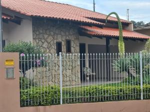 a white fence in front of a house at Casa Itoupava Norte in Blumenau