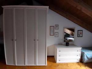 a bedroom with white cabinets and a bed and a dresser at La dimora delle corti in Vanzone