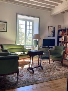 a living room with green furniture and a table at Les Tourellières 