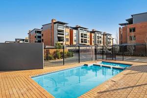 a swimming pool in front of some tall buildings at Airport Heights II in Boksburg
