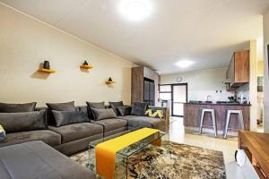 a living room with a couch and a kitchen at Airport Heights II in Boksburg