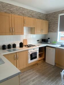 a kitchen with wooden cabinets and white appliances at hewitt place in Crewe