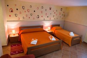 2 camas en una habitación con sábanas de color naranja en Le Stanze del Re, en Lamezia Terme