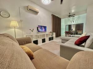 a living room with a couch and a tv at Mijanna Guesthouse - Johor Bahru in Johor Bahru