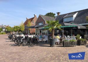 a cobblestone street with tables and bikes parked in front of a restaurant at Chaletpark de Lits in Oostermeer