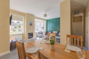 a dining room with a wooden table and chairs at Stylish beachfront apartment in historic Deal in Kent