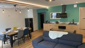 a living room with a couch and a table and a kitchen at LE CHOUCAS - LA MONGIE in Bagnères-de-Bigorre