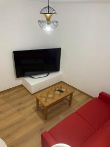 a living room with a red couch and a coffee table at LE CHOUCAS - LA MONGIE in Bagnères-de-Bigorre