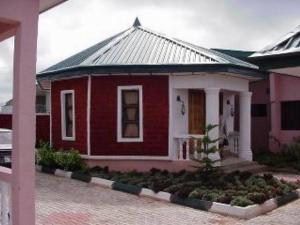 einem roten und weißen Haus mit in der Unterkunft Room in Lodge - Garentiti Apartment - Silver Room in Iyiba