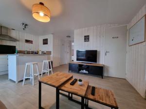 a living room with a table and a kitchen at Chalet 6 pers à 10km de Cabourg in Dozulé
