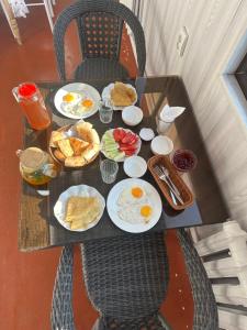 a table with plates of eggs and toast on it at Kerben House in Naryn