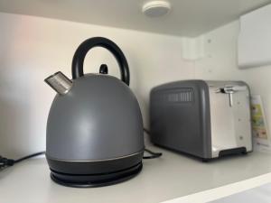 a tea kettle on a counter next to a printer at Ferienwohnung Moments klimatisiert in Balingen