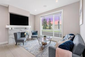 ein Wohnzimmer mit einem Kamin und einem TV in der Unterkunft Modern Altadore Home 3 Br Fireplace Sleeps 8 in Calgary