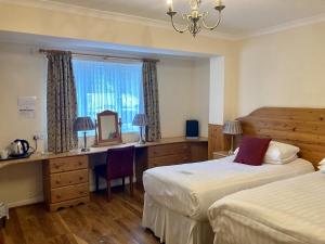a hotel room with two beds and a desk and a mirror at The Bentley Brook Inn in Thorpe