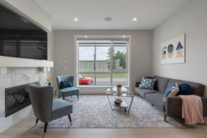 ein Wohnzimmer mit einem Sofa, Stühlen und einem Kamin in der Unterkunft Modern Altadore Home 3 Br Fireplace Sleeps 8 in Calgary