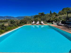 einen Pool mit Stühlen und Bergen im Hintergrund in der Unterkunft 3 guests Pool villa-Jacuzzi infinity pool in wondrous gardens that surround in Spoleto