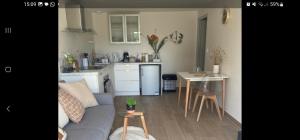 a living room with a couch and a kitchen at Studio du Quintinet in Le Quillio