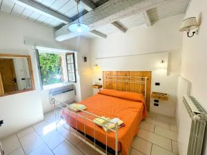 ein Schlafzimmer mit einem orangenen Bett in einem Zimmer in der Unterkunft 3 guests Pool villa-Jacuzzi infinity pool in wondrous gardens that surround in Spoleto