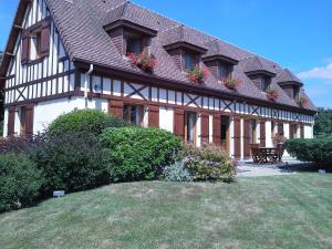 uma casa grande com caixas de flores nas janelas em Chambres d'Hôtes Au Temps Des Cerises em Jumièges