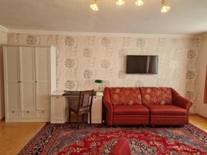 sala de estar con sofá rojo y TV en Hotel Haus Bremen garni en Bremen