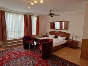 ブレーメンにあるホテル　ハウス　ブレーメン　ガルニのベッド、テーブル、椅子が備わるホテルルームです。