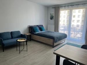 sypialnia z łóżkiem, kanapą i stołem w obiekcie Harmonia Apartments w Szczecinie