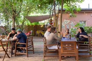 a group of people sitting at tables in a garden at EastSeven Berlin Hostel in Berlin