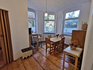a dining room with a table and chairs and windows at Ferienwohnung Auf dem Georgenberg in Naumburg