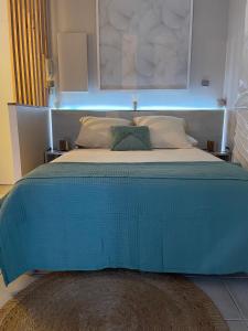 a bed with a blue cover on top of it at Le Coeur DAISY'L Saint Denis Centre in Saint-Denis