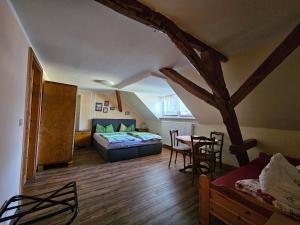 a bedroom with a bed and a table in a room at Pension Zur Kutscherstube in Colditz