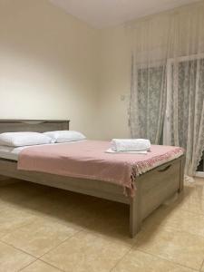 カリテア・ハルキディキにあるCenter Kallithea Apartmentのベッドルーム1室(ピンクのシーツが備わる大型ベッド1台付)