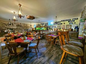 ein Restaurant mit Holztischen und -stühlen und einer Bar in der Unterkunft Pension Zur Kutscherstube in Colditz