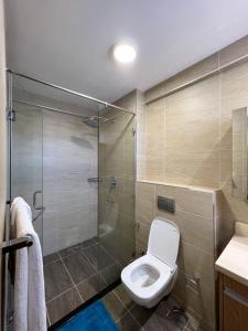 a bathroom with a toilet and a glass shower at Shared room in three bedrooms, private bathroom, gym, office area, kitchen, Wonderiss Home Westland Living in Nairobi