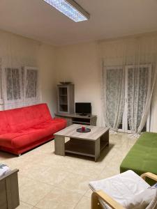 カリテア・ハルキディキにあるCenter Kallithea Apartmentのリビングルーム(赤いソファ、テーブル付)