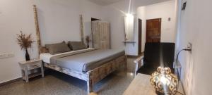 a bedroom with a bed and a chair in it at SHANKAR by the SEA, 2 min from Mandrem Beach in Mandrem