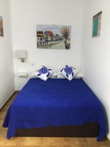 a bedroom with a blue bed with blue and white pillows at Apartamentos Playamar II in Valle Gran Rey