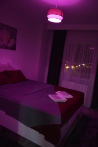 Dormitorio púrpura con cama con luz púrpura en Hera Emlak en Kırac