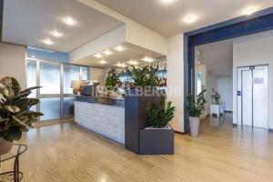 an office lobby with a counter with potted plants at Esperia Boutique Family Hotel in Cesenatico