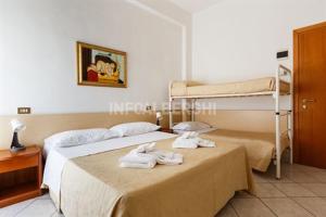 a bedroom with two beds and a bunk bed at Esperia Boutique Family Hotel in Cesenatico